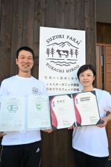 ISO22000の認証を取得した鈴木牧場の鈴木さん(左)と、登録証を持つ食品安全チームリーダーのなつきさん