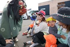 獅子舞を怖がる子どもたち(24日午前10時半ごろ、助川かおる通信員)