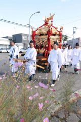 青空の下、市内を回るみこし(24日午前10時20分ごろ、助川かおる通信員)