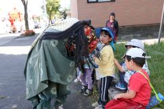 獅子舞を怖がる子どもたち(24日午前10時20分ごろ、助川かおる通信員)