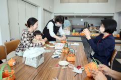 講師の飯島さん(右から2人目)のアドバイスで籠作りに挑戦する母親ら