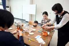 講師の飯島さん(右)のアドバイスで籠作りに挑戦する母親ら