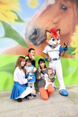 フレップとファイターズガールの高野実さんと記念撮影する家族連れ(助川かおる通信員撮影)