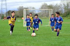 【U9クラスAブロック・オンオールホワイト―音更ユニオン】ボールを追う(青色のユニホームの)音更ユニオンの選手ら