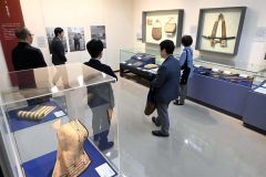 大和田さんの解説を聞きながら展示資料を見る内覧会参加者