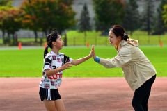 タッチを交わし、子どもを応援する福島さん(右)=金野和彦撮影