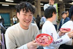 限定500食の「生本マグロ丼」を手にする買い物客(29日午前9時50分ごろ、須貝拓也撮影)