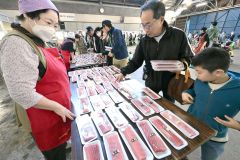 解体したばかりのマグロの柵売りで品定めする買い物客(29日午前9時45分ごろ、須貝拓也撮影)