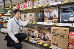 カセットガス式の暖房を紹介する尾崎副店長。サイズや暖房性能が人気の理由という(ジョイフルエーケー帯広店)