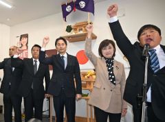 ガンバローの掛け声に合わせて拳を突き上げる中川氏(右から2人目)ら