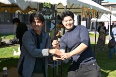 カエルの脚の唐揚げを買う客(右)と手渡すスタッフ