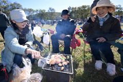 会場内で焼き肉を楽しむ来場者(13日午前10時40分ごろ、須貝拓也撮影)