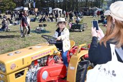 展示された年代物トラクターで記念撮影する親子(13日午前10時40分ごろ、須貝拓也撮影)