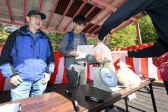野菜重量当てクイズで奮闘する出場者(13日午前10時半ごろ、須貝拓也撮影)