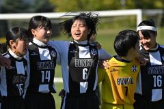 仲間と肩を組んで優勝を喜ぶ道文教大付のMF古村誉(中央)