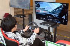 eスポーツブースでレースゲームをする来場者