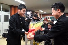 前主将の村中大河さん(右)から花束を受け取る澁谷純希投手(24日午後8時ごろ、帯広農業高校で。塩原真撮影)