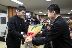 前主将の村中大河さん(右)から花束を受け取る澁谷純希投手(24日午後8時ごろ、帯広農業高校で。塩原真撮影)