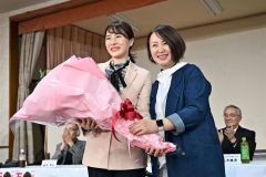 「リラの風」の佐々木直美会長(右)から花束を受け取る石川香織氏(27日午後8時45分ごろ、塩原真撮影)