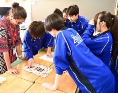 東ティモール出身の(左)マリアさんにすごろくを紹介する生徒たち